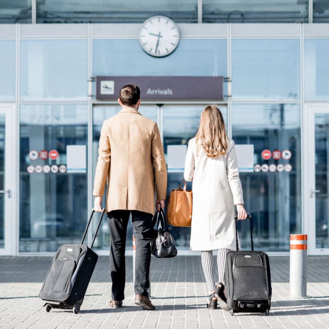 Man and woman facing airport entrance