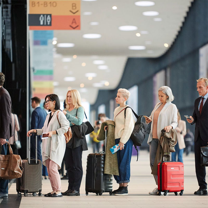 Air General Traveler concierge assisting travelers in a modern airport terminal